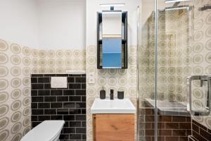 W łazience znajduje się umywalka, toaleta i lustro. w obiekcie Sali Homes - FeWo Blühendes Barock Ludwigsburg w mieście Ludwigsburg