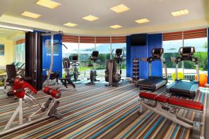 a gym with several treadmills and cardio machines at Aloft Bursa Hotel in Bursa