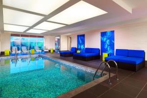 a hotel lobby with a pool and blue furniture at Aloft Bursa Hotel in Bursa
