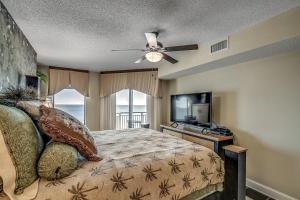 een slaapkamer met een bed en een flatscreen-tv bij South Wind Penthouse 3 in Myrtle Beach