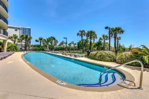 a swimming pool in a resort with palm trees at South Wind Penthouse 3 in Myrtle Beach