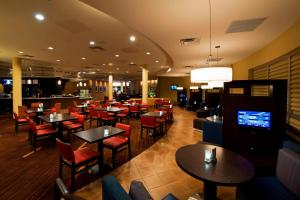 a restaurant with tables and chairs and a bar at Courtyard by Marriott Ottawa East in Ottawa