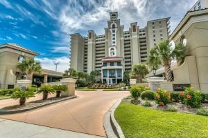 a large building with palm trees and a driveway at South Wind Penthouse 3 in Myrtle Beach