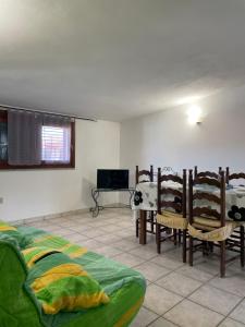 uma sala de estar com uma cama, uma mesa e cadeiras em La casa di Tonia em La Caletta