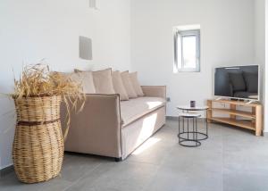a living room with a couch and a table at Santa Marina Syros in Liaropá