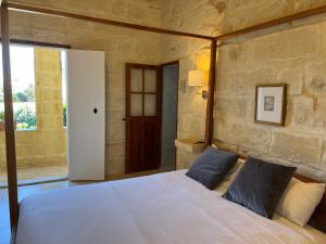 a bedroom with a large white bed with blue pillows at Razzett Ghasri in Għasri