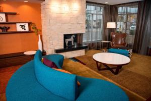 a living room with a blue couch and a fireplace at Fairfield Inn & Suites by Marriott Cincinnati Uptown/University Area in Cincinnati