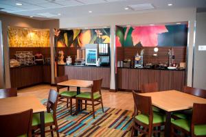 a restaurant with tables and chairs and a bar at Fairfield Inn & Suites by Marriott Cincinnati Uptown/University Area in Cincinnati