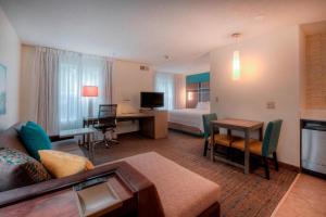 a hotel room with a bed and a living room at Residence Inn by Marriott Wilmington Landfall in Wilmington
