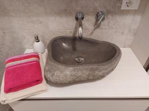 um lavatório numa casa de banho com uma toalha rosa em Apartment Sonne auf Bio-Hof em Merano