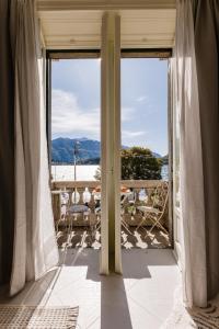 una puerta abierta a un balcón con vistas al océano en Bella Belle Griante, en Cadenabbia