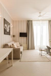 Sala de estar blanca con sofá y mesa en Bella Belle Griante, en Cadenabbia