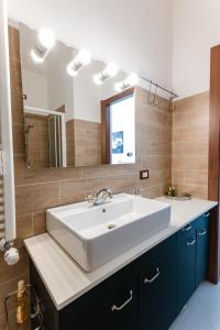 a bathroom with a white sink and a mirror at Bella Belle Griante in Griante Cadenabbia