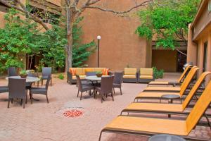 a patio with wooden tables and chairs and a building at Courtyard Santa Fe in Santa Fe