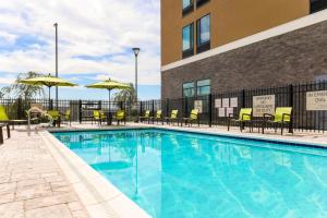a swimming pool at a hotel with chairs and umbrellas at SpringHill Suites by Marriott San Jose Fremont in Fremont