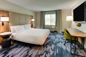 a hotel room with a large bed and a desk at Fairfield by Marriott Inn & Suites Dalton in Dalton