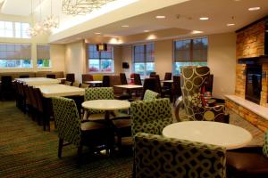 a restaurant with tables and chairs and windows at Residence Inn by Marriott Sebring in Sebring