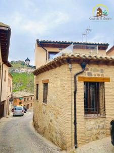 a stone building with a car parked on a street at Casa de la GALERA in Toledo
