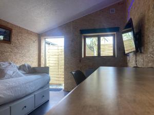 a room with a large wooden table and a bed at Studio avec terrasse et parking au Mans in Le Mans
