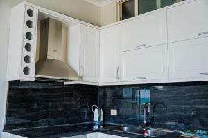 Apartament CDS في دوريس: مطبخ مع دواليب بيضاء ومغسلة