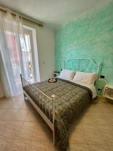 una camera con un letto con una parete verde di La Casa di Ele, parcheggio privato gratuito a La Spezia