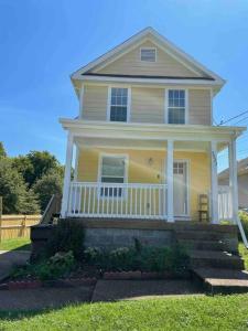 a yellow house with a white porch and stairs at Look No Further! in Nashville