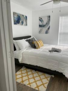um quarto com uma cama com lençóis brancos e almofadas em Look No Further! em Nashville