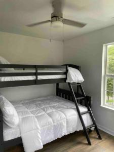 a bedroom with a bunk bed with a ceiling fan at Look No Further! in Nashville