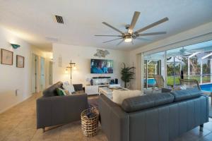 a living room with two couches and a ceiling fan at Villa Holiday Sunrise II in Cape Coral