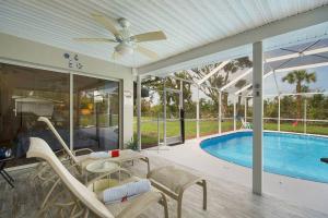 a patio with a table and chairs and a pool at Villa Holiday Sunrise II in Cape Coral