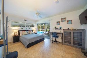 a bedroom with a bed and a desk and a ceiling fan at Villa Holiday Sunrise II in Cape Coral +18 photos