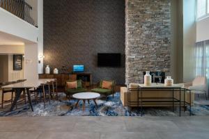 eine Lobby mit Tischen und Stühlen und einer Ziegelwand in der Unterkunft Fairfield Inn & Suites by Marriott Destin in Destin