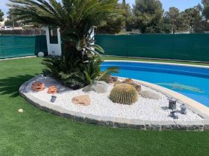 una isla de cactus en la hierba junto a una piscina en Big house with swimming pool, en Segur de Calafell