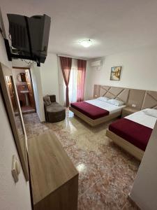 a hotel room with two beds and a flat screen tv at Apartments Near The Coast - Milla in Ulcinj