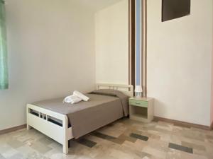 una piccola camera con letto e comodino di Casa CanEli a Pachino