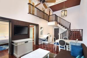 a living room with a television and a dining room at Sheraton Samui Resort in Chaweng Noi Beach