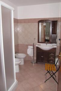 uma casa de banho com um lavatório, um WC e um espelho. em B&B Sole del Pollino em Rotonda
