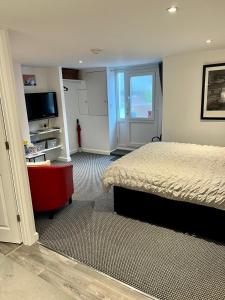 a hotel room with a bed and a television at Basement Studio by the Bay in Morecambe