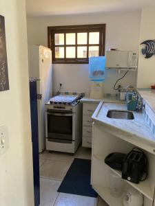 a small kitchen with a stove and a sink at Casa em Búzios com Vista para o Mar in Búzios