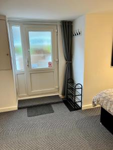 a bedroom with a door with a window and a bed at Basement Studio by the Bay in Morecambe