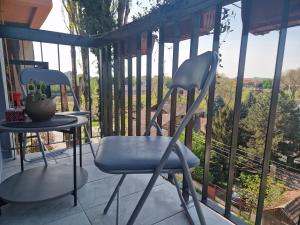 two chairs and a table on a balcony with a view at Aparmani Djuric in Subotica