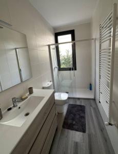 bagno con lavandino, servizi igienici e finestra di Villa del Mas Pinell a L'Estartit