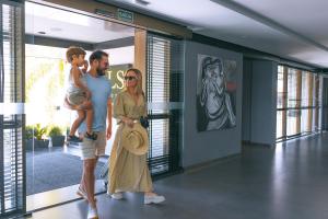 a man and a woman holding a child in a building at LS Hotel in João Pessoa +90 photos