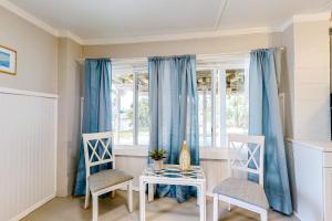 a dining room with blue curtains and a table and chairs at 7213 Flood Reef - Unit 4 in Pensacola