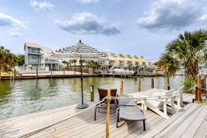 a dock with two chairs and an umbrella on the water at 7213 Flood Reef - Unit 4 in Pensacola