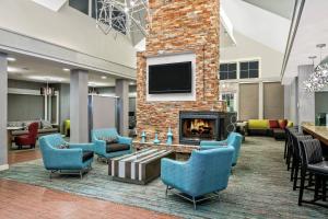 a lobby with a fireplace and chairs and a tv at Residence Inn by Marriott San Antonio SeaWorld / Lackland in San Antonio