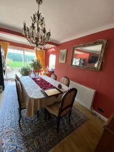 a dining room with a table and a mirror at Zen Cottage, Cheltenham in Cheltenham
