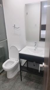 a white bathroom with a toilet and a sink at HOTEL GALLERY URBAN in Bogotá
