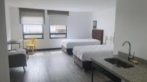 ein Hotelzimmer mit 2 Betten und einem Waschbecken in der Unterkunft HOTEL GALLERY URBAN in Bogotá