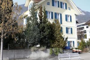 dos bancos blancos frente a un edificio en Barlis - stilvolle Ferien in typischem Dorfhaus, en Alpnach